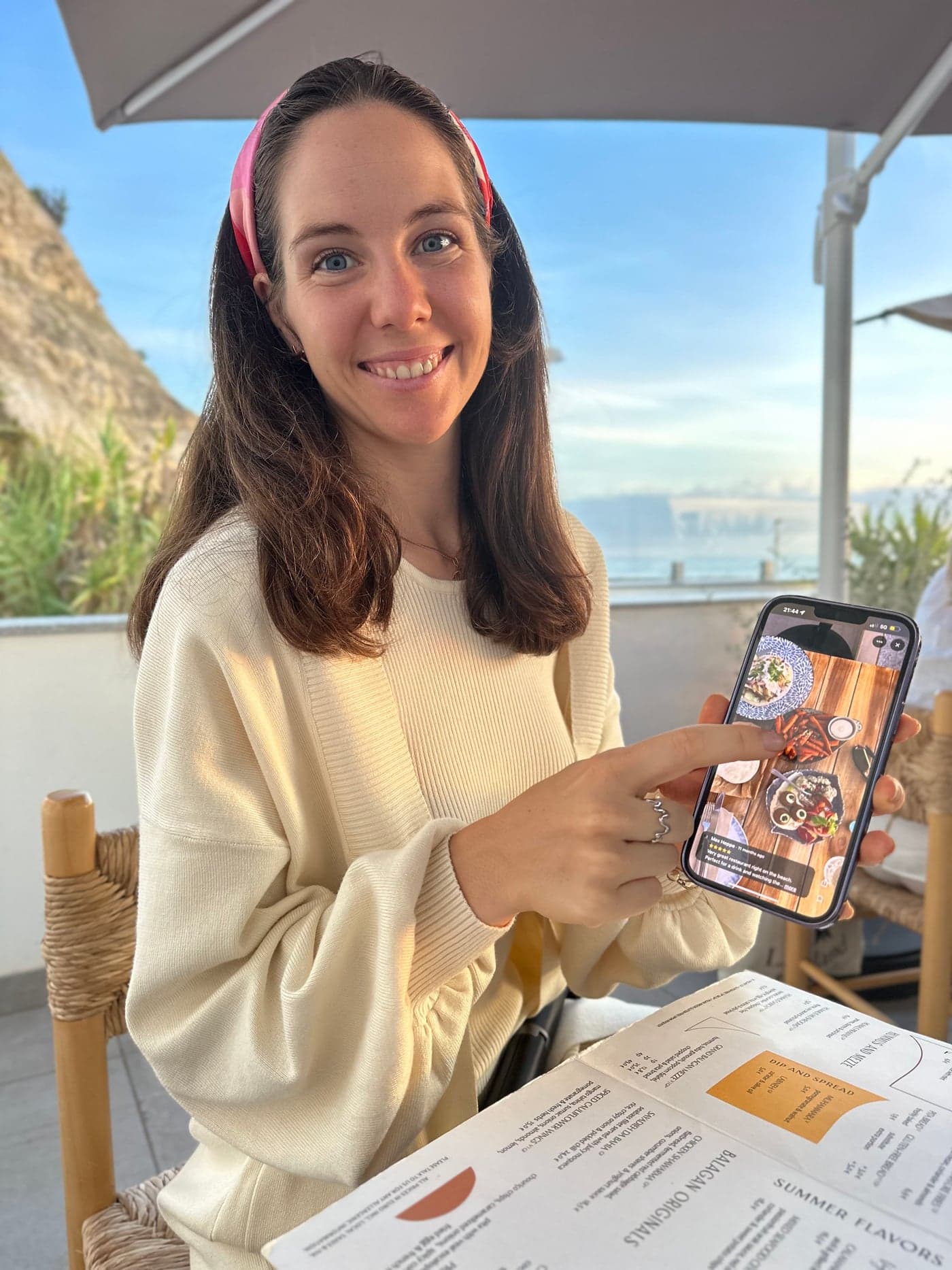 Julia, founder of Travel-Luck, sharing a travel map by the sea